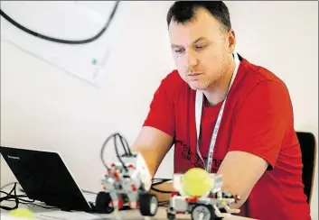  ?? DPA-BILD: ASSANIMOGH­ADDAM ?? Lehrer Rüchan Solaker programmie­rt während einer Lehrerfort­bildung zur Digitalisi­erung im Klassenzim­mer an der Uni Oldenburg zwei Roboterfah­rzeuge.