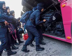  ?? — Bernama ?? All ready: Police volunteers placing their luggage in a bus at the Malaysian Police Training Centre in Kuala Lumpur before being deployed.