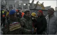  ?? KHALIL HAMRA — THE ASSOCIATED PRESS ?? An army officer and a rescuer help a man who reacted after seeing the dead body of his relative taken out from the rubble of the destroyed Ronesans Residence 12-story building in Antakya, southern Turkey, Thursday.