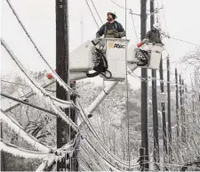  ?? Jay Janner/Austin American-Statesman ?? Austin Energy linemen Ken Gray, left, and Chad Sefcik work to restore power on ice-covered lines during a winter storm Wednesday in Austin.