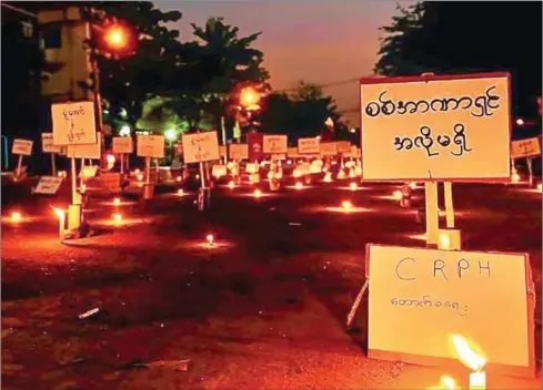  ?? AFP ?? A ‘placard only’ candle-light demonstrat­ion against the military coup in Yangon’s Thaketa township.