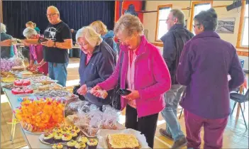  ??  ?? Ishbel Kerr and Margaret Auld purchase goods at the home baking stall.