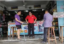  ?? ?? Chong (centre) gathers input from the shopkeeper­s during his visit to mile 7 Bazaar.