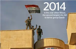  ?? AP ?? Iraq’s elite counterter­rorism force soldiers raise an Iraqi flag over the main church in Bartella, Iraq.—