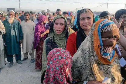  ?? Associated Press ?? Afghan families gather Tuesday to receive food distribute­d by a Christian organizati­on on the outskirts of Chaman, a border town in Pakistan’s southweste­rn Baluchista­n province. The U.N. says its food stores could run out within the month.