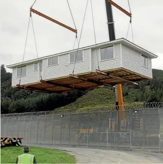  ??  ?? A house built by eight prisoners is lifted over the wire at Upper Hutt’s Rimutaka Prison.