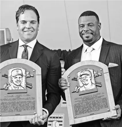  ?? GREGORY J. FISHER, USA TODAY SPORTS ?? Mike Piazza and Ken Griffey Jr. show off their Hall of Fame plaques during the induction.
