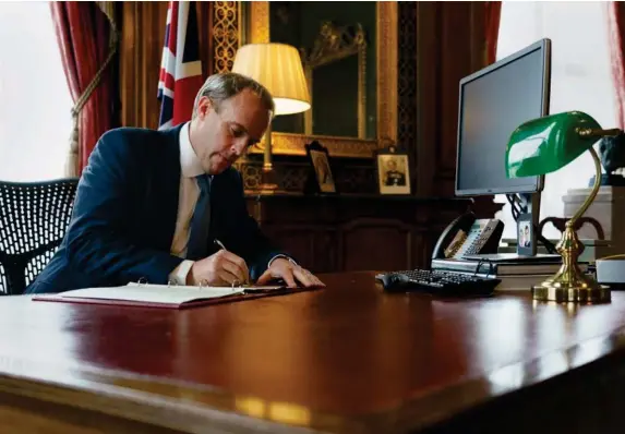  ??  ?? Dominic Raab signs a letter to MPs following the new sanctions (AFP/Getty)