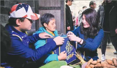  ?? PROVIDED TO CHINA DAILY ?? Yao Weiwei (right), general manager of PepsiCo Greater China, delivers a package to a poverty-stricken mother in Mashan county, the Guangxi Zhuang autonomous region.