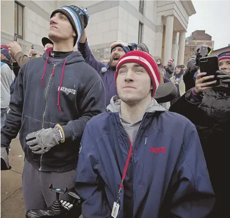  ?? STAFF PHOTO BY MARK GARFINKEL ?? IN THE MOMENT: Best friends Adam Ascensao, left, and Jack Trottier watch the Patriots duck boats roll along New Chardon Street during yesterday’s Super Bowl victory parade.