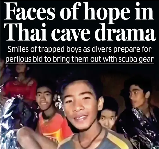  ??  ?? We’re okay: Members of the trapped soccer team smile for the camera in footage taken by Thai special forces divers