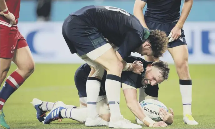  ??  ?? 2 John Barclay is congratula­ted by Duncan Taylor after scoring Scotland’s eighth try during the victory over Russia.