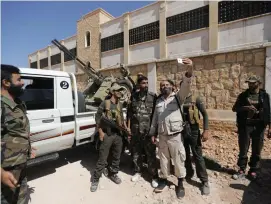  ?? (Khalil Ashawi/Reuters) ?? A MEMBER of Jaish al-Islam takes a selfie with a mobile phone in the town of Soussian earlier this week.