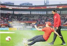  ?? FOTO: AFP ?? Eine Helferin fiel beim Versuch, einen Probeschus­s aufs Tor zu bringen, am Samstag auf den nassen Rasen. Jones tat es richtig leid.