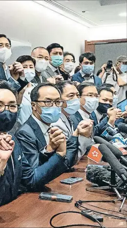  ?? ANTHONY KWAN / GETTY ?? Frente común. Los diputados prodemocra­cia de Hong Kong se dan la mano al anunciar su decisión de dimitir en bloque del Parlamento, que queda en manos de los afines de Pekín