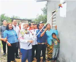  ??  ?? Datuk Amar Hajah Jamilah Anu mengecat rumah salah seorang penerima bantuan PPRT Baik Pulih Rumah sebagai acara simbolik Baik Pulih Rumah Kampung Sungai Belian.