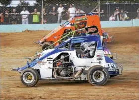  ??  ?? Jake Severn runs in between Nick Havens (#93k) and Sam Kravitsky (#14) during 600 Micro Sprints race as they accelerate out of turn four and onto the front straight.