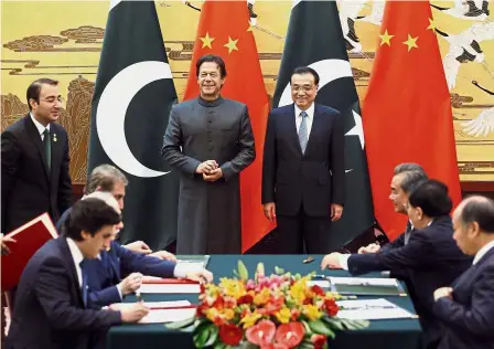  ?? — AP ?? Close allies: Khan and Li attending a signing ceremony at the Great Hall of the People in Beijing.