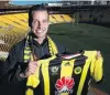  ?? PHOTO: GETTY IMAGES ?? New Phoenix signing and former Newcastle United player Steven Taylor holds a Wellington Phoenix shirt during his announceme­nt at Westpac Stadium in Wellington yesterday.