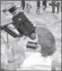  ?? (File Photo/AP/Joe Holloway Jr.) ?? Steve Spalding of Chattanoog­a, Tenn. squints through the viewfinder of a movie camera March 7, 1970, at a Valdosta industrial park as the solar eclipse begins in Valdosta, Ga.