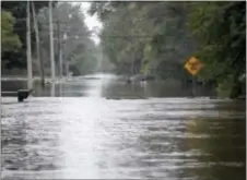  ?? TIFFANY RUSHING — THE COURIER VIA AP ?? Flood waters close McCoy Road on Saturday in Evansdale, Iowa. Authoritie­s in several Iowa cities were mobilizing resources Friday to handle flooding from a rain-swollen river that has forced evacuation­s in several communitie­s upstream.