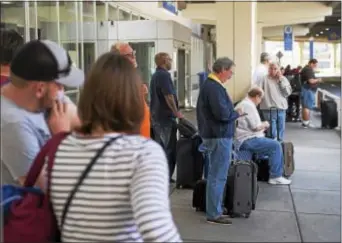  ?? RICK KAUFFMAN — DIGITAL FIRST MEDIA ?? Travelers await transit outside the terminal at Philadelph­ia Internatio­nal Airport on as droves of people arrived from hurricane-threatened regions down south. Friday