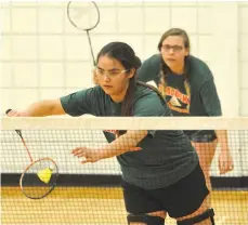  ??  ?? Peacock’s Allison Billy serves in front off teammate Chantal Usher during high school girls doubles badminton action Tuesday.