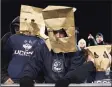  ?? Jared Wickerham / Getty Images ?? UConn fans wear bags on their heads during a 2013 game against Louisville in East Hartford.