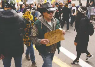  ?? IAN KUCERAK ?? A counter-protester carries a simple sign with a message favoured by many in Alberta.