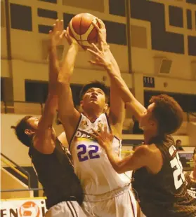  ?? FILE ?? CONSOLATIO­N.Elmer Orano (22) of University of Negros Occidental Recoletos goes against two La Consolacio­n College defenders during their eliminatio­n round match. UNO-R finished third, while La Consolacio­n got second place.SUNSTAR