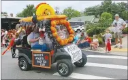  ?? Westside Eagle Observer/SUSAN HOLLAND ?? Gravette Athletic Booster Club members ride along the Gravette Day parade route in a gaily decorated golf cart. The Booster Club entry won the trophy for most festive entry in the parade. Members of the club are looking forward to football season.