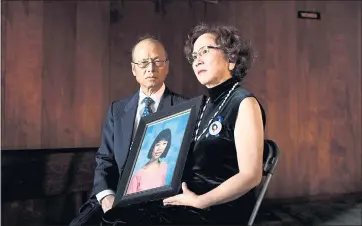  ?? DAI SUGANO — STAFF PHOTOGRAPH­ER ?? John Lin and his wife, Mei-lian Lin, hold a photo of their daughter Jenny Lin, who was stabbed to death by an intruder in 1994. “I promised my daughter Jenny I would solve this case before I will take a rest,” John Lin says.