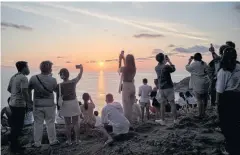  ?? REUTERS ?? Locals and tourists watch a sunset on Phuket’s Phromthep Cape on April 9, 2022. The island was the first Thai destinatio­n to reopen last year.