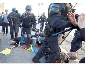  ?? — Reuters ?? Strong arm: People laying on the ground as riot police try to disperse them during the 19th round of ‘yellow vests’ protests in Nice.