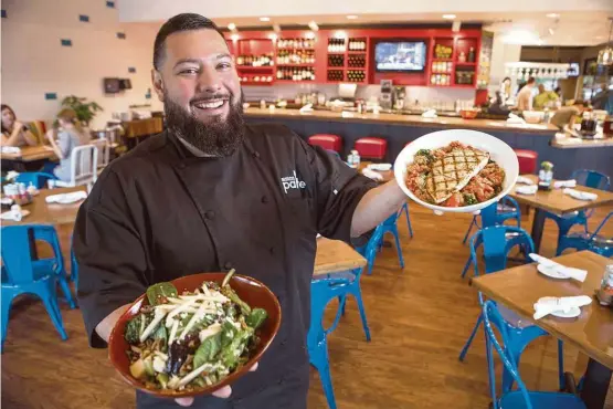  ?? Brett Coomer photos / Houston Chronicle ?? Pablo Gomez, corporate chef with Hospitalit­y USA, serves healthful fare at Restless Palate, such as kale, pear and pecan salad, left, and herb-grilled salmon.