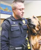  ?? Arnold Gold / Hearst Connecticu­t Media ?? State Trooper Edward Anuszewski with his K-9 partner, Texas, a bloodhound tracking dog, at the State Police Canine Unit Training Center in Meriden on March 10.