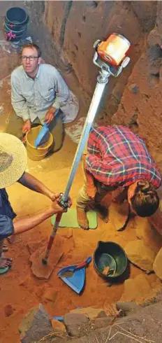  ?? Reuters ?? Top: Three axes and a rectangula­r sharpening stone discovered during excavation­s. Above: Scientists at work during excavation­s.