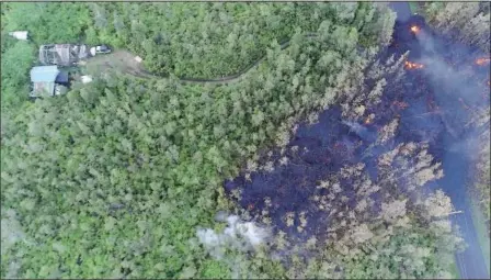  ?? BYRON MATTHEWS VIA THE ASSOCIATED PRESS ?? In a still frame from video, lava flows toward a home in the Puna District on Friday as a result of the eruption from the Kilauea volcano on Hawaii’s Big Island. Since Kilauea’s eruption early last week, residents have witnessed the dangers of lava and...