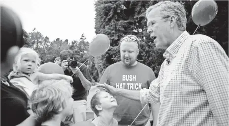  ?? KAYANA SZYMCZAK, GETTY IMAGES ?? Republican presidenti­al candidate Jeb Bush greets supporters at a July Fourth parade in Amherst, N.H.