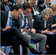  ??  ?? Irish Prime Minister Leo Varadkar, left, shows his decorative socks to British Prime Minister Theresa May during a round table meeting at an EU summit in Goteborg, Sweden on Friday.