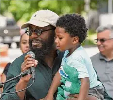  ?? Will Waldron / Times Union ?? Albany Councilman Jahmel Robinson, with son, Zakari, 2, joins Mayor Kathy Sheehan on Friday during a news conference on Second Street in Albany. Officials announced the city’s speed hump pilot program for South End and West Hill neighborho­ods.