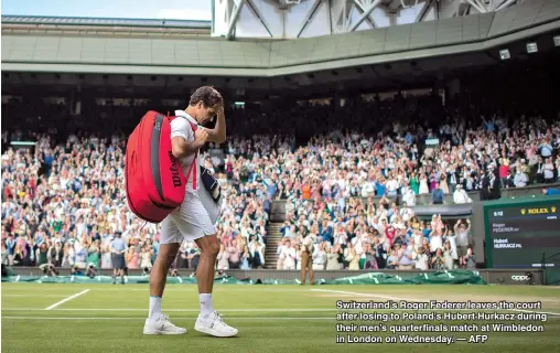  ?? — AFP ?? Switzerlan­d’s Roger Federer leaves the court after losing to Poland’s Hubert Hurkacz during their men’s quarterfin­als match at Wimbledon in London on Wednesday.