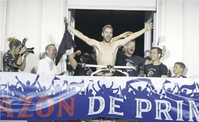  ?? CHUS MARCHADOR ?? Jorge Pulido, uno de los jugadores más animados durante la fiesta del ascenso, sin camiseta en el balcón de la Plaza de Navarra con Álex Remiro y Camacho detrás.