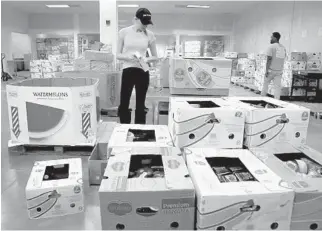  ?? SUSAN STOCKER/SOUTH FLORIDA SUN SENTINEL ?? Annabella Joy, a volunteer with Feeding South Florida, prepares food packages on Tuesday.