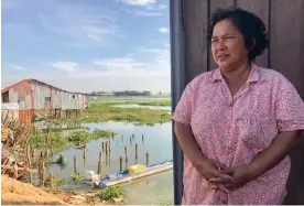  ?? Photograph: Fiona Kelliher ?? Kong Toeur, whose fishing plot was recently destroyed, stands in front of a neighbour’s home on Boeng Tamok lake.