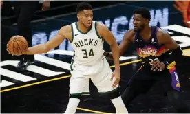  ?? Petersen/Getty Images ?? The Bucks’ Giannis Antetokoun­mpo handles the ball against the Suns’ Deandre Ayton during a Feburary game. Antetokoun­mpo’s fitness is a major question ahead of Tuesday’s opening game of the NBA finals between Milwaukee and Phoenix. Photograph: Christian