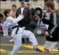  ??  ?? Josh Morris demonstrat­es his martial arts kicks with others from Competitiv­e Edge.
