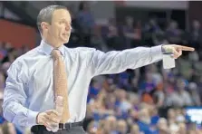  ?? RON IRBY/ ASSOCIATED PRESS ?? UF head coach Mike White, pointing instructio­ns to his team last season, was known to break into gyms to play games of pick-up basketball as a youth. Now he plays with his Gators’ coaching staff.