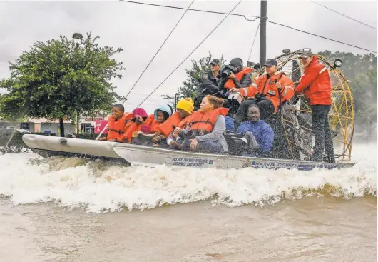  ?? SCOTT CLAUSE, USA TODAY NETWORK ?? Volunteers and first responders work together to rescue the stranded from rising floodwater­s in Houston. Tropical Storm Harvey on Tuesday continued to bring rain to already saturated areas along the coast. Rick Jervis and John Bacon