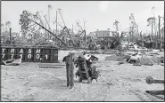  ?? AP/GERALD HERBERT ?? Robert Edmonson rests Wednesday after pulling a dolly through sand as he helps salvage belongings from his brother-in-law’s hurricane-destroyed home in Mexico Beach, Fla.